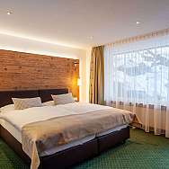 Bright room with double bed and view of snowy landscape.