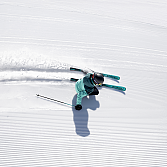 Ein Skifahrer fährt über eine frisch präparierte Schneepiste.