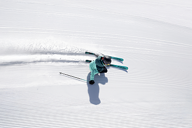 A skier is skiing over a freshly prepared snow slope.