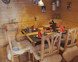 Wooden table with dishes and decoration in a rustic room.