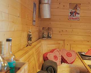 Interior view of a wooden room with cushions and decoration.