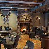 Elegante Lounge mit Kamin, bequemen Sitzgelegenheiten und rustikalem Dekor.