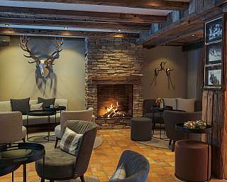 Elegante Lounge mit Kamin, bequemen Sitzgelegenheiten und rustikalem Dekor.