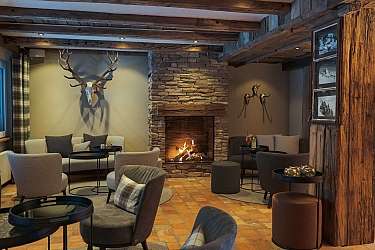 Elegant lounge with a fireplace, comfortable seating, and rustic decor.