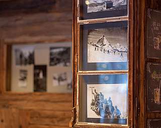 Ein Holzrahmen mit historischen Schwarz-Weiß-Fotos und Getränkekarten.