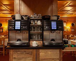 Two modern coffee machines in a rustic restaurant.