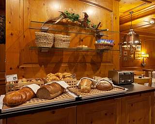 Variety of fresh bread and pastries in a cosy restaurant.