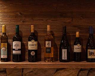 Reihe von Weinflaschen auf einem Holzregal.