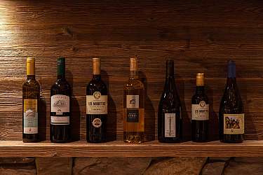A selection of wine bottles on a wooden shelf.
