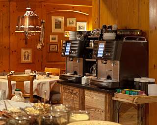 Two coffee machines in a cosy restaurant with wooden decor.