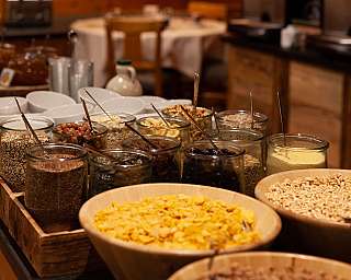 Glasses with various grains and nuts on a breakfast buffet.