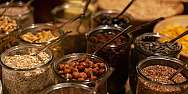 Glasses with various types of grains and nuts on a table.
