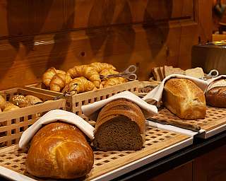A selection of fresh bread and rolls on a table.
