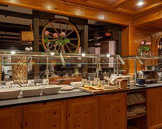 A buffet with various dishes in a wooden restaurant.