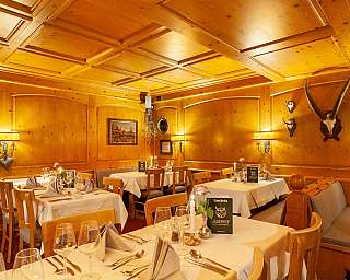 Ein rustikales Restaurant mit Holzwänden und elegant gedeckten Tischen.