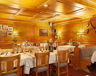 Ein rustikales Restaurant mit Holzwänden und elegant gedeckten Tischen.