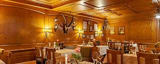 Elegant restaurant with wooden walls and set tables.