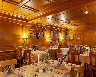 Ein stilvolles Restaurant mit Holzwänden und eleganten Tischdekorationen.