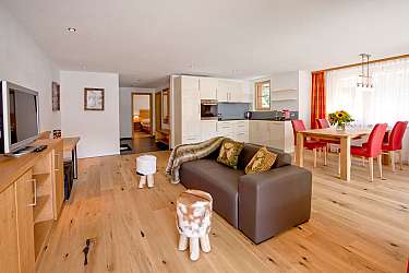 Helle, offene Wohnküche mit gemütlichem Essbereich und Holzfußboden.