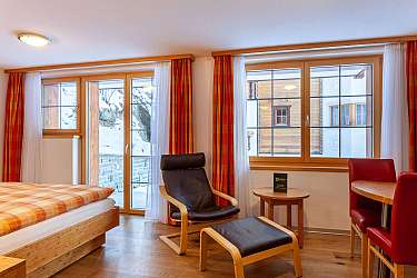 Gemütliches Zimmer mit Holzdetails und Blick auf den Schnee.