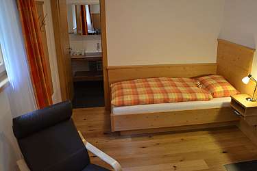 Ein einfaches Schlafzimmer mit einem Bett und einem Blick auf das Badezimmer.