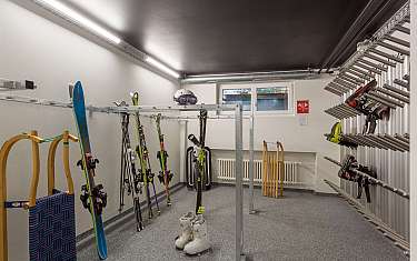 Une salle de ski avec des skis, des chaussures de ski et une luge.