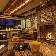 A stylish living space with a fireplace, comfortable furniture, and warm lighting.