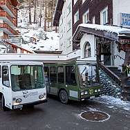Zwei Fahrzeuge vor dem Hotel Jägerhof in verschneiter Umgebung.