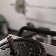 Schwarze Gewichtsscheibe auf einem Hantelständer im Fitnessstudio.