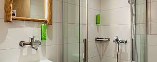 Helles Badezimmer mit Dusche und Waschbecken.