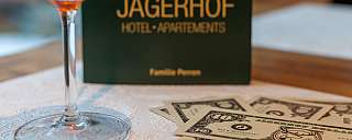 A cocktail glass and play money on a table.