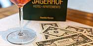 Ein Cocktailglas neben Jägerhof Dollar-Scheinen auf einem Tisch.