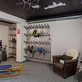 Ein Skiraum mit Skiern, Schlitten und Sitzgelegenheit.