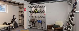 A ski room with skis, sledges, and seating.