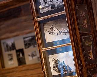 Schwarze und weiße Fotos in einem Holzrahmen, mit Berglandschaft.