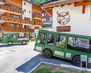 Green vehicle in front of the Jägerhof Hotel in the Alps.
