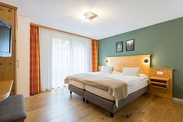 Modern bedroom with wooden details and adjoining bathroom.