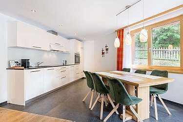 Bright kitchen with dining area and red chairs.