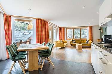Bright, open-plan kitchen with a cozy dining area and wooden floor.