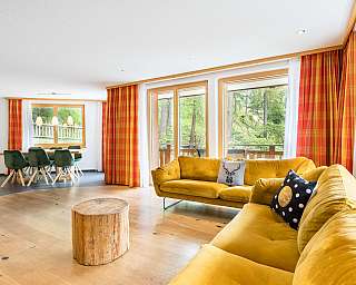 Bright kitchen with red chairs and a dining table.