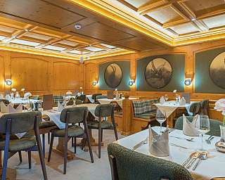 Restaurant mit Holzwänden, gedeckten Tischen und Tierbildern an der Wand