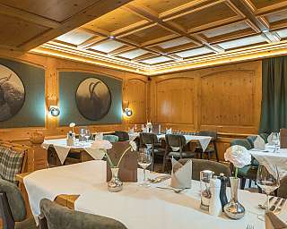 Restaurant mit Holzwänden, gedeckten Tischen und dekorativen Blumenvasen