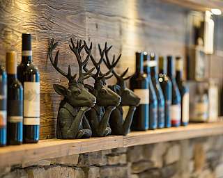 Row of wine bottles on a wooden shelf.