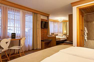 Ein modernes Hotelzimmer mit Fenster, Tisch und TV.