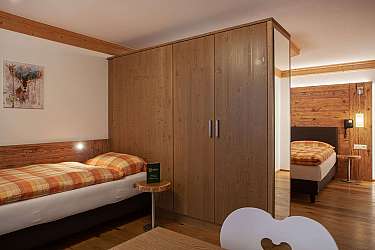 Ein modernes Schlafzimmer mit zwei Betten und Holzschränken.